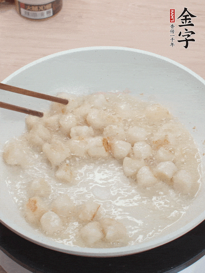 油溫4成熱，鮮貝蘸干淀粉下鍋煎，一面微黃后翻面。