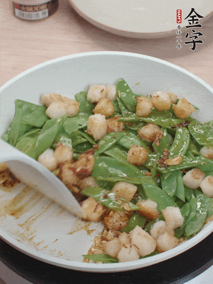 下甜豆莢、鮮貝輕輕翻炒均勻。