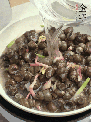 倒處理干凈的螺螄翻炒，加3勺料酒。加清水蓋過(guò)螺螄，中火蓋蓋煮5分鐘。