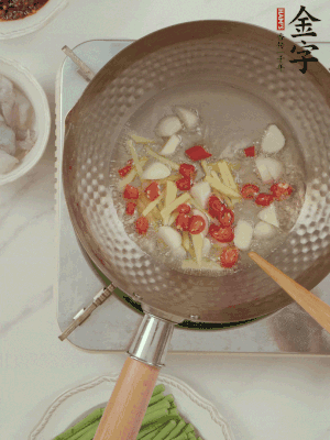 油7成熱時(shí)，下大蒜粒、姜絲、小米辣煸香。